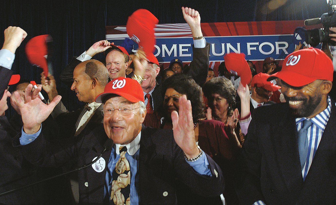 Baseball announcer Charlie Brotman, bottom left, and others who helped bring baseball to Washington, sing Take me out to the ball game after announcing that Major League Baseball has decided to move the Montreal Expos to the nation's capitol during a news - Washingtonian (UPI Photo/Roger L. Wollenberg)