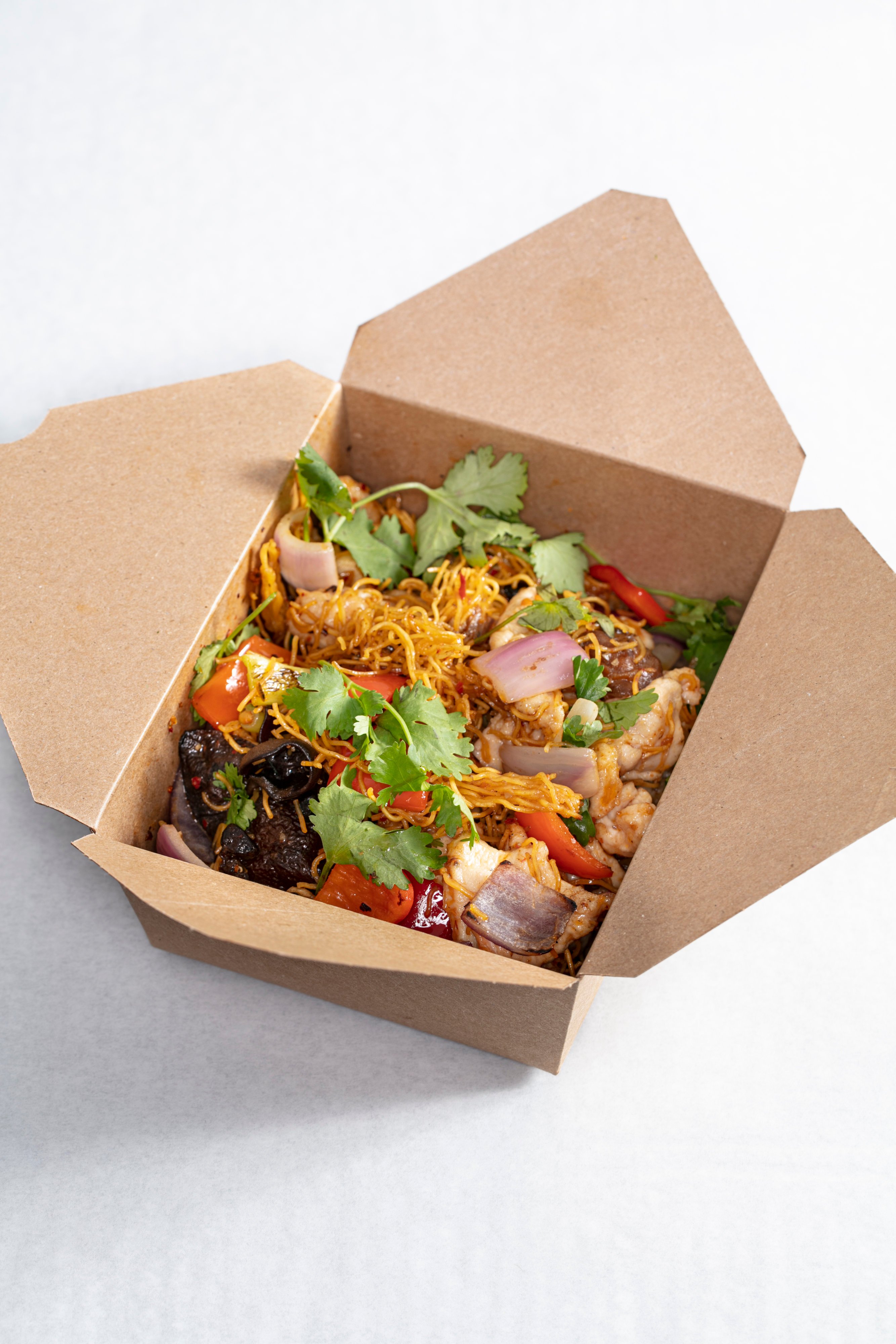 Sustainable packaging, like the recyclable containers for the chili chicken chow mein, is a priority for the team. Photo by Melissa Hom. 