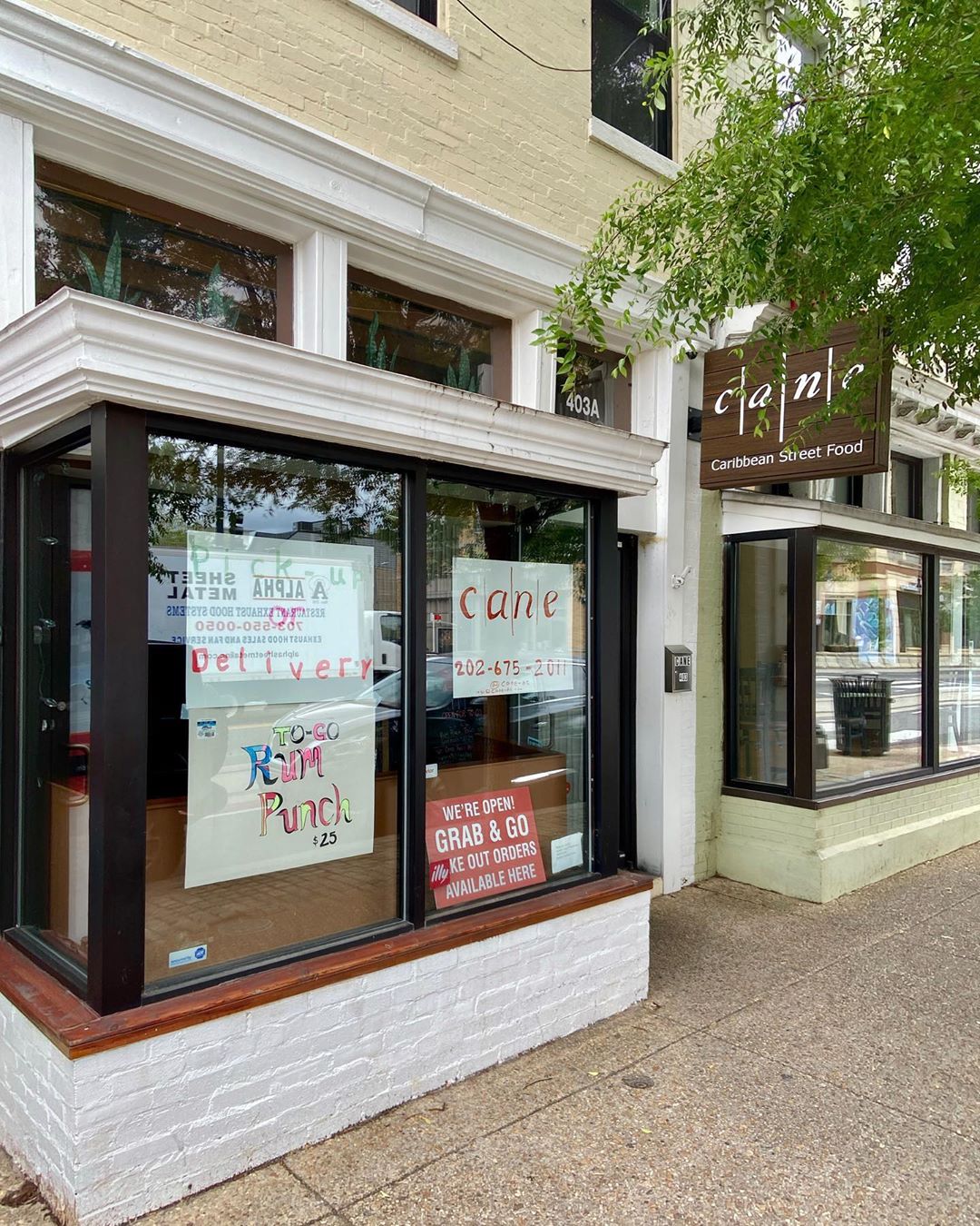 Signs announcing takeout, delivery, and to-go rum punch at H Street restaurant Cane. Photo courtesy of DC Public Library.