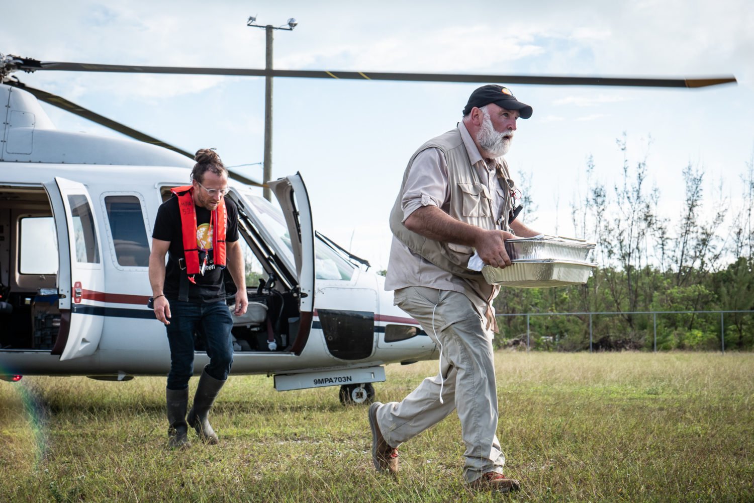 The chef with a hot meal and a helicopter in the Bahamas. Photo courtesy of World Central Kitchen.