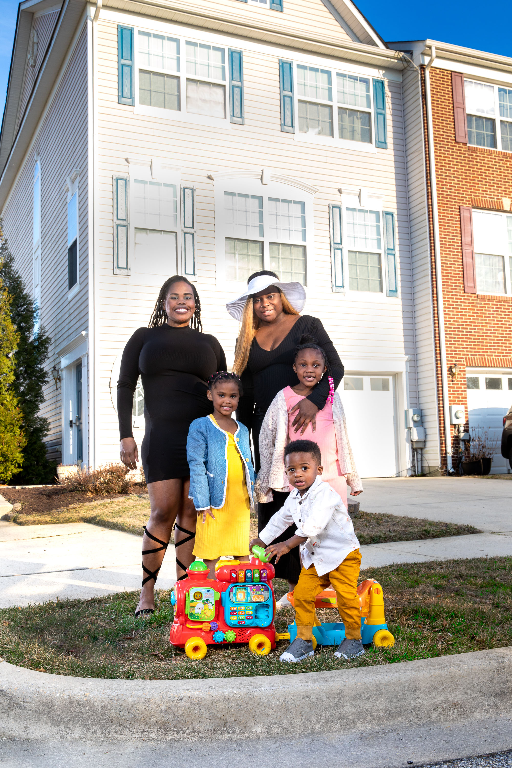 (L-R) Raquel Poindexter and sister De'Ja Irvin with her children: Cassiah Irvin (in yellow) , Cassidy Irvin (in pink), and R'eighn Irvin (train) gather for a family photo outside their new residence in highly sought-after community in Brandywine, Maryland.