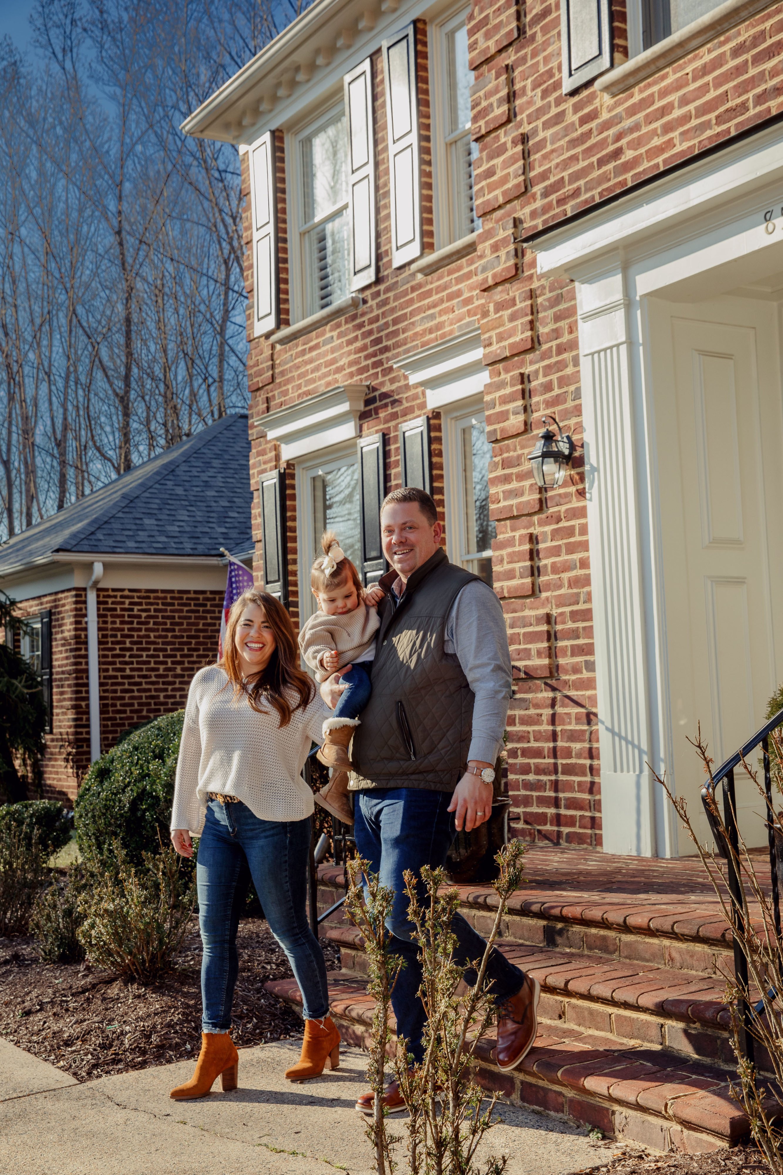 Brian and Kristen Frazier step outside with their 16 month old daughter, Olivia, and embrace in front of their new home in Great Falls, VA.