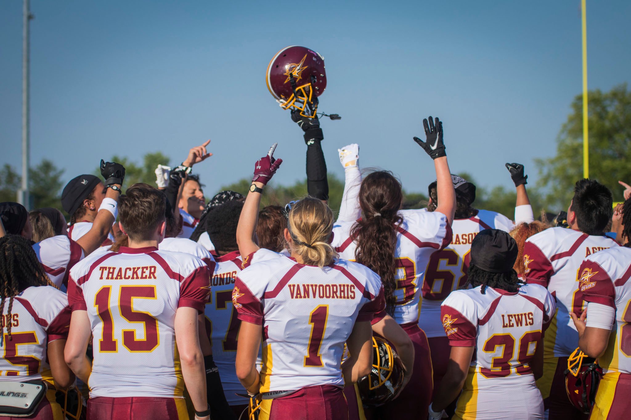 The D.C. Divas football team gathers on the field to chant before a game