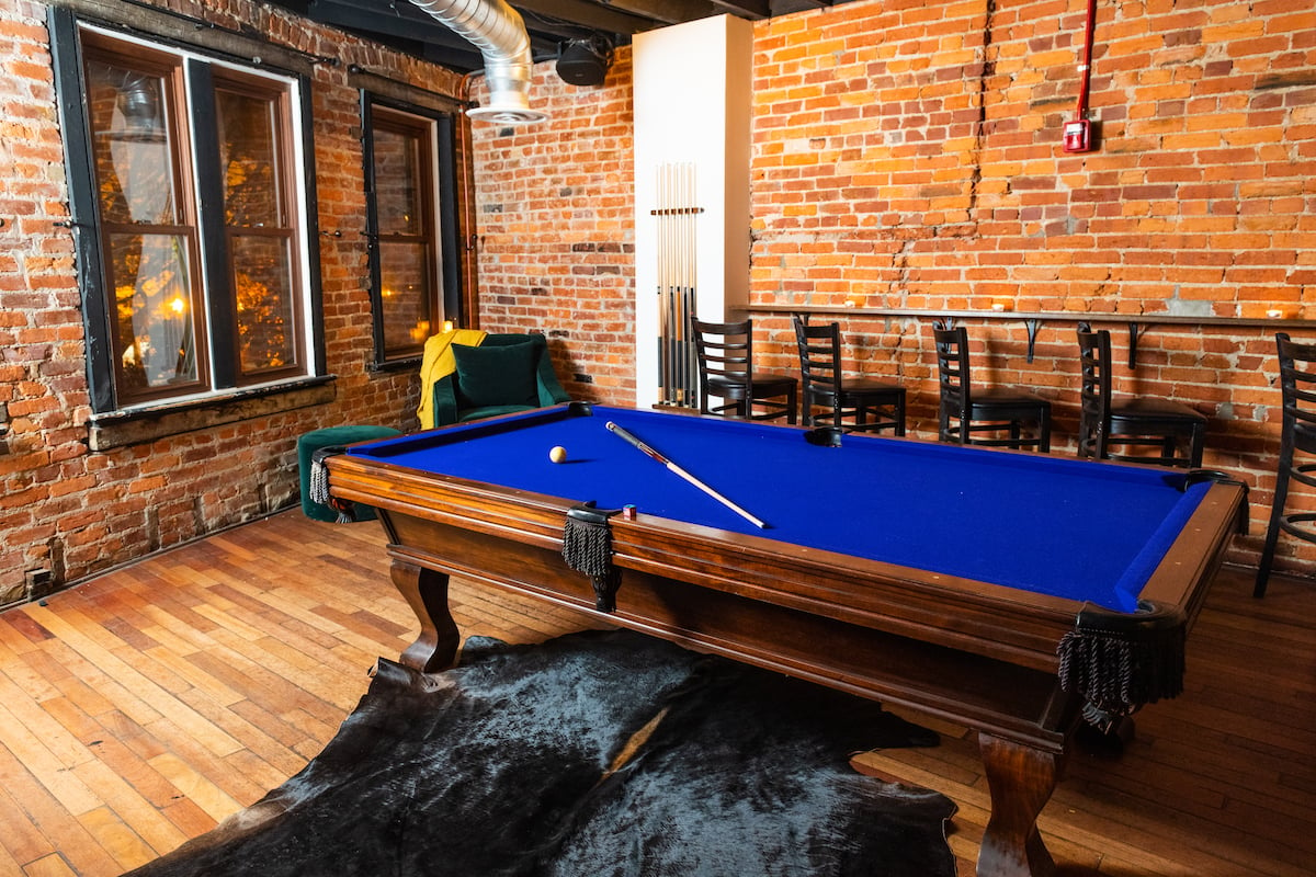 The second floor features dark wood, more dining space, and a billiards room. Photograph by Clarissa Villondo