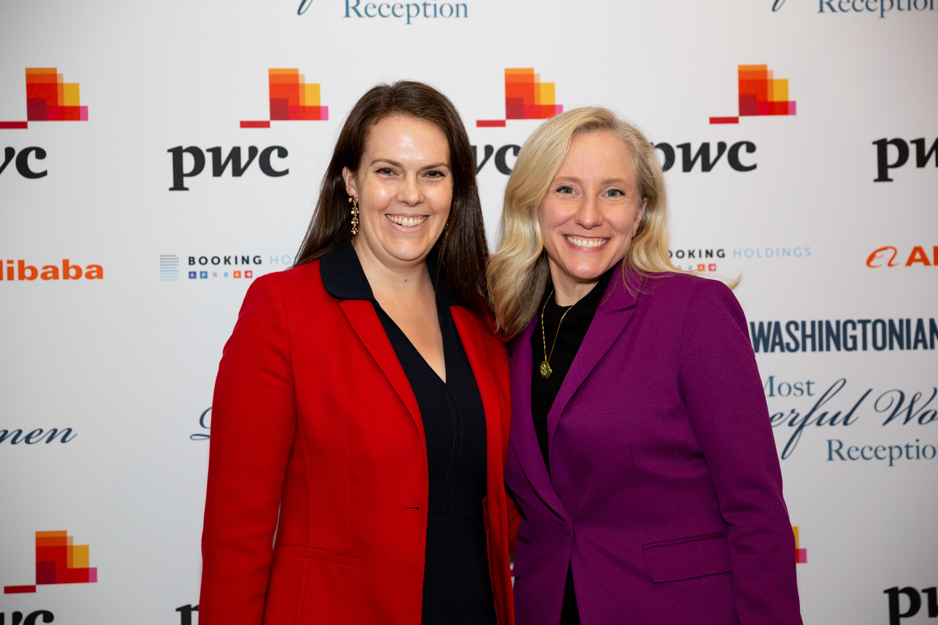 2 women in front of a step and repeat smiling at the camera