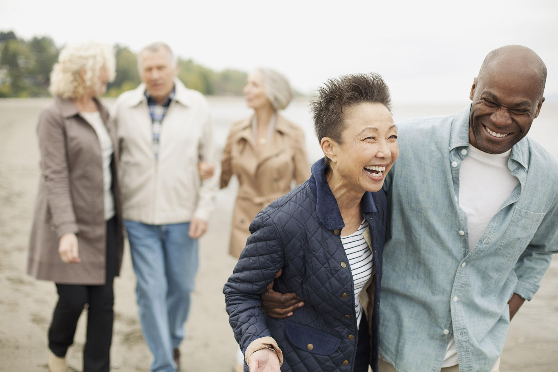 mature friends walking along the beach - Washingtonian