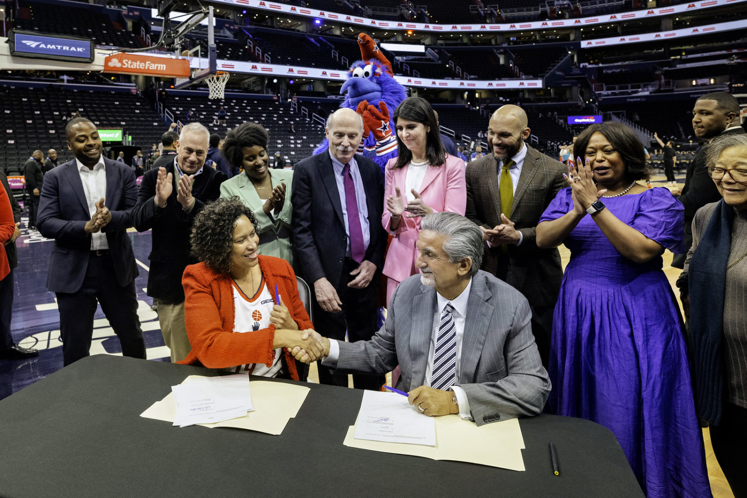 Ted Leonsis and Muriel Bowser shake hands.