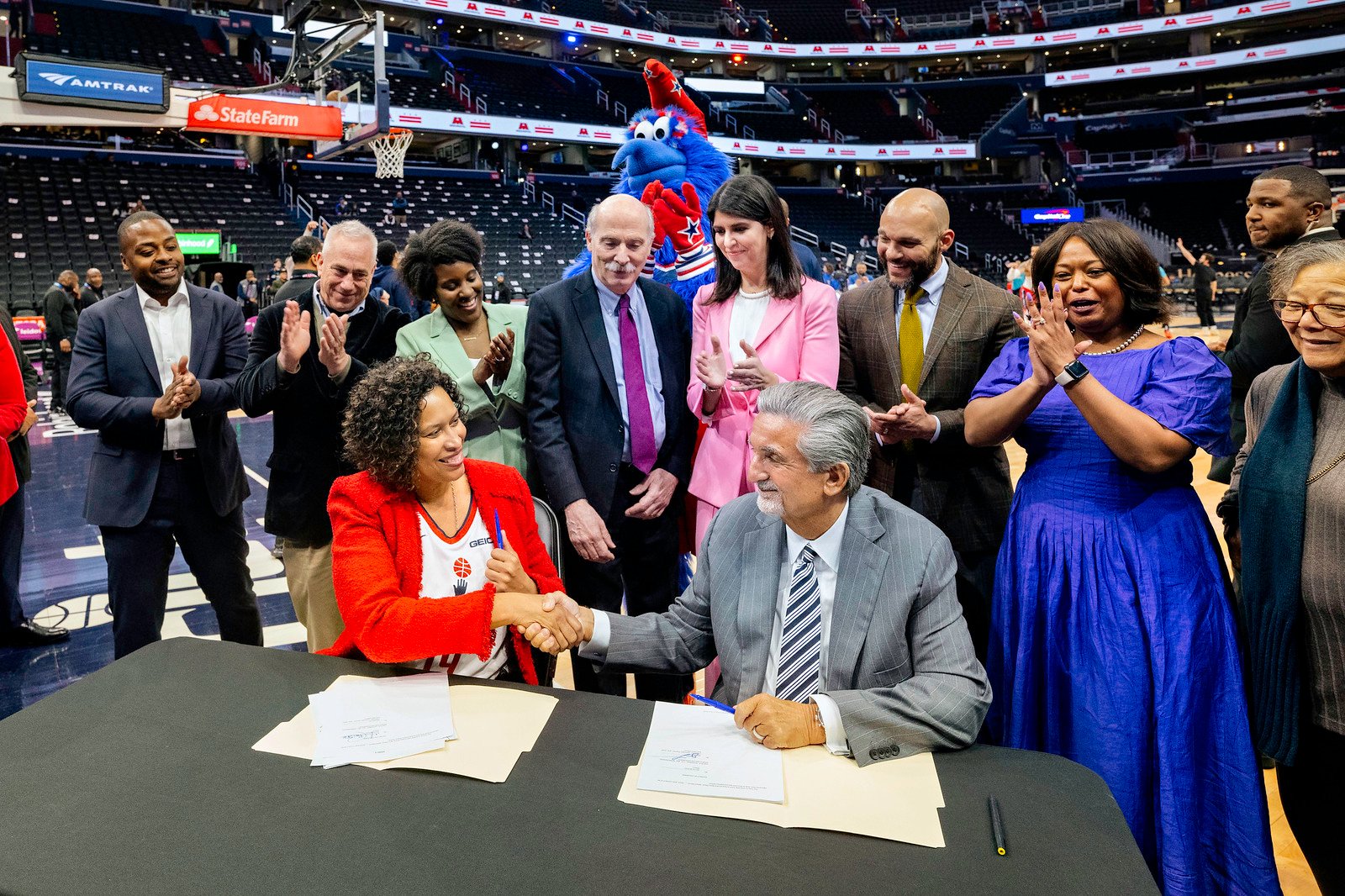 Ted Leonsis and Muriel Bowser shake hands.